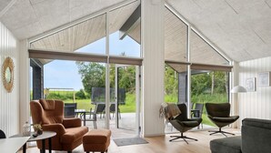 A spacious living area with large sliding glass doors leading to an outdoor patio. - 5 Star Holiday Home in Glesborg (Glesborg)