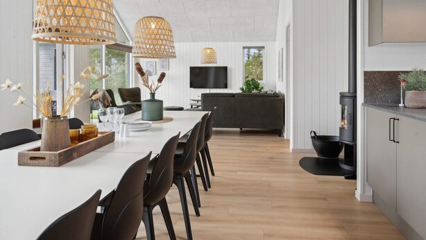 A modern kitchen with a built-in stove, wooden flooring, and pendant lighting. - 5 Star Holiday Home in Glesborg (Glesborg)