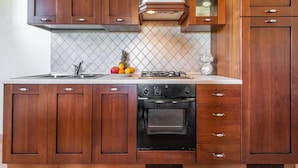 Une cuisine avec des meubles de rangement en bois, une cuisinière et un évier.