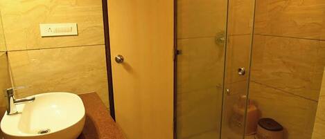Un baño con lavabo, cabina de ducha de vidrio y inodoro.