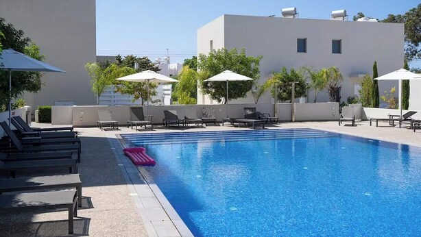 Ein Pool auf dem Dach mit Liegestühlen und Sonnenschirmen.