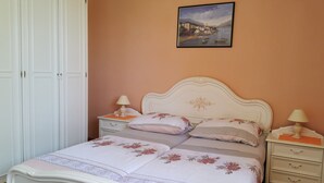 Ein Schlafzimmer mit einem Bett, zwei Nachttischen, einer Kommode und einem Kleiderschrank.