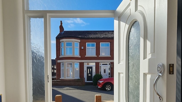 A door leading to a residential street with a red car parked outside. - 4-BR Liverpool House Free Parking (Liverpool)