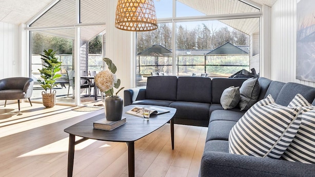 Uma sala de estar moderna com um sofá, uma mesa de centro e um lustre.