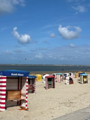 Beach huts with striped awnings, some with names like "Heidi-Maus" and "Ostinga 54". - Cozy vacation home Alte Dorfschule (Krummhörn)