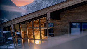 A wooden cabin with large windows, a balcony, and a view of snow-capped mountains. - Apartment mit 1 Schlafzimmer fur 2 Personen (Kaprun)