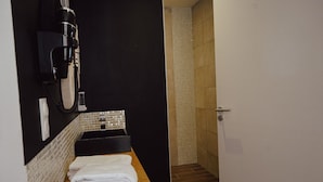A bathroom with a black sink, a towel rack, and a shower area. - Les Résidences Gueguen - Suite Les Clos (Chablis)