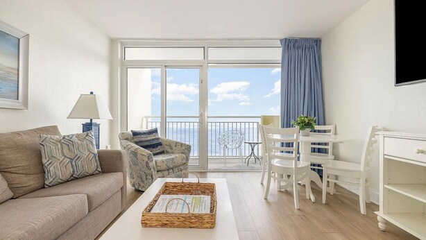 Un salon moderne avec un canapé, une table basse et un balcon offrant une vue agréable.