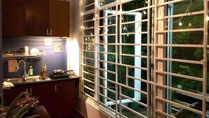 A kitchen with a large window, cabinets, and a sink. - The Vinh Homestay (Ho Chi Minh City)