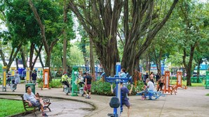 A park with exercise equipment, benches, and trees. - The Vinh Homestay (Ho Chi Minh City)