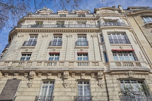 A classical building with ornate architectural details, multiple balconies, and large windows. - Luxurious airconditioned apartment Arc de Triomphe (Paris)