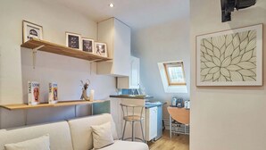 Een compacte woonruimte met een bank, een kitchenette, een eethoek en een kleine bar.