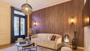 A modern living room with a beige sofa, a round coffee table, and a decorative vase. - Superb Apartment Terrace Champs Elysees (Paris)