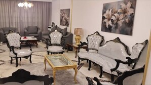 A living room with a sofa set, a coffee table, and a television.