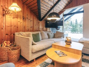 A cozy living room with a sofa, a coffee table, and a television mounted on the wall. - 6 Person Holiday Home in Fjerritslev (Fjerritslev)