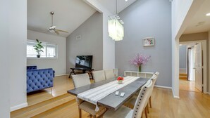 A dining area with a long table, chairs, and a TV in the background. - 6 Mi to Dtwn Garland: Group Getaway w/ Pool Access (Garland)