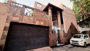 A modern building with a stone facade, a closed garage door, and a parked white car.