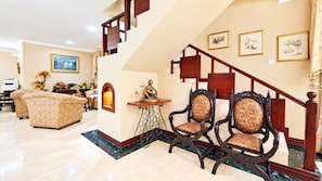 A spacious living area with a staircase, a sofa set, and a decorative table.