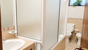 A bathroom with a sink, mirror, toilet, and shower. - Barnes Place Grand Residence Colombo 7 (Colombo)