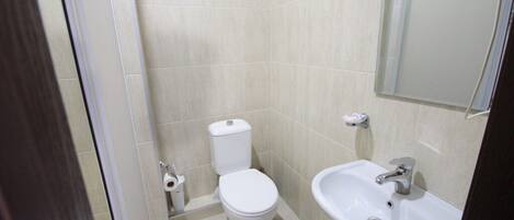 Un bagno piccolo e pulito, con toilette, lavandino e specchio.