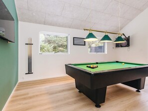 A pool table with a green felt surface, a dartboard, and overhead lighting. - 5 Star Holiday Home in Blokhus (Blokhus)
