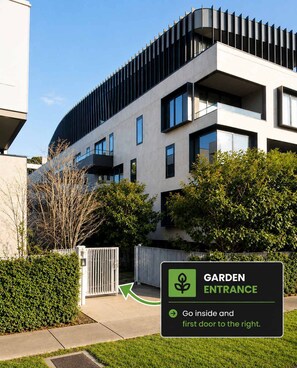 A modern building with a garden entrance sign directing to the right.