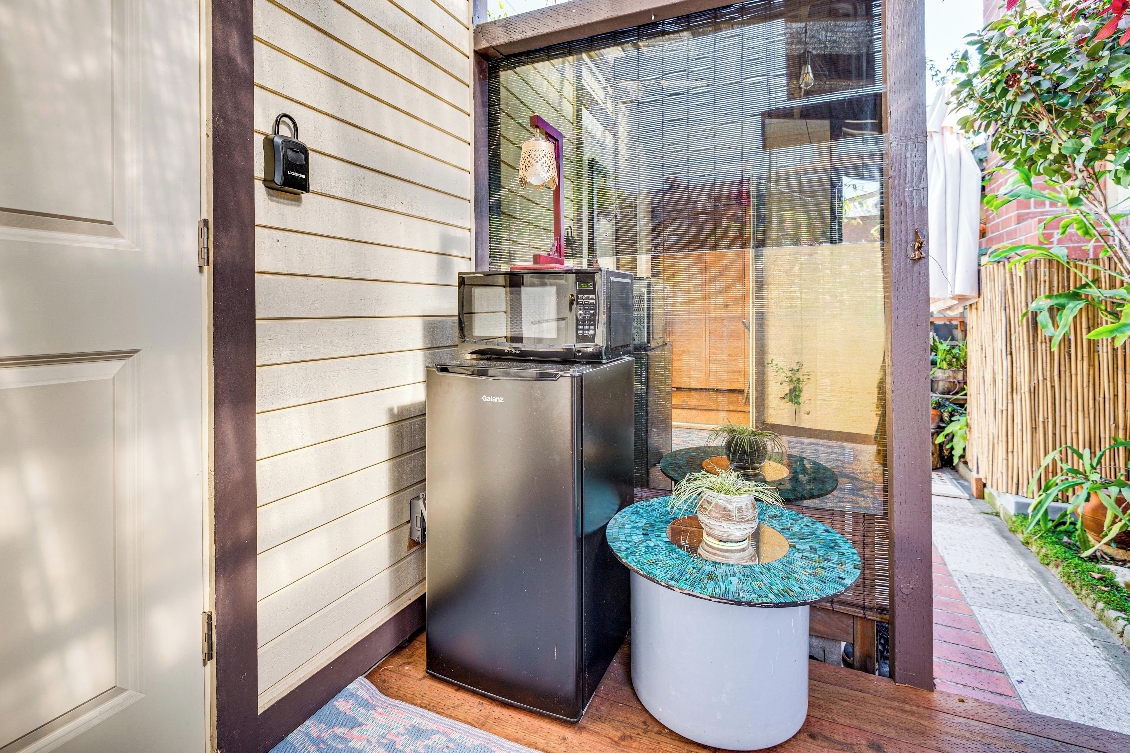 A compact kitchen with a microwave, a small table with a decorative centerpiece, and a door with a lock.