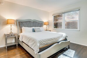 A neatly made bed with a grey headboard, two bedside tables with lamps, and a window with blinds. - 'peacock House Sanctuary' 4 Mi to Old Pasadena! (Pasadena)