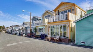 A row of coastal houses with balconies, a street lamp, and a clear blue sky. - Walk to Bay & Pleasure Pier! Catalina Island Stay (Avalon)