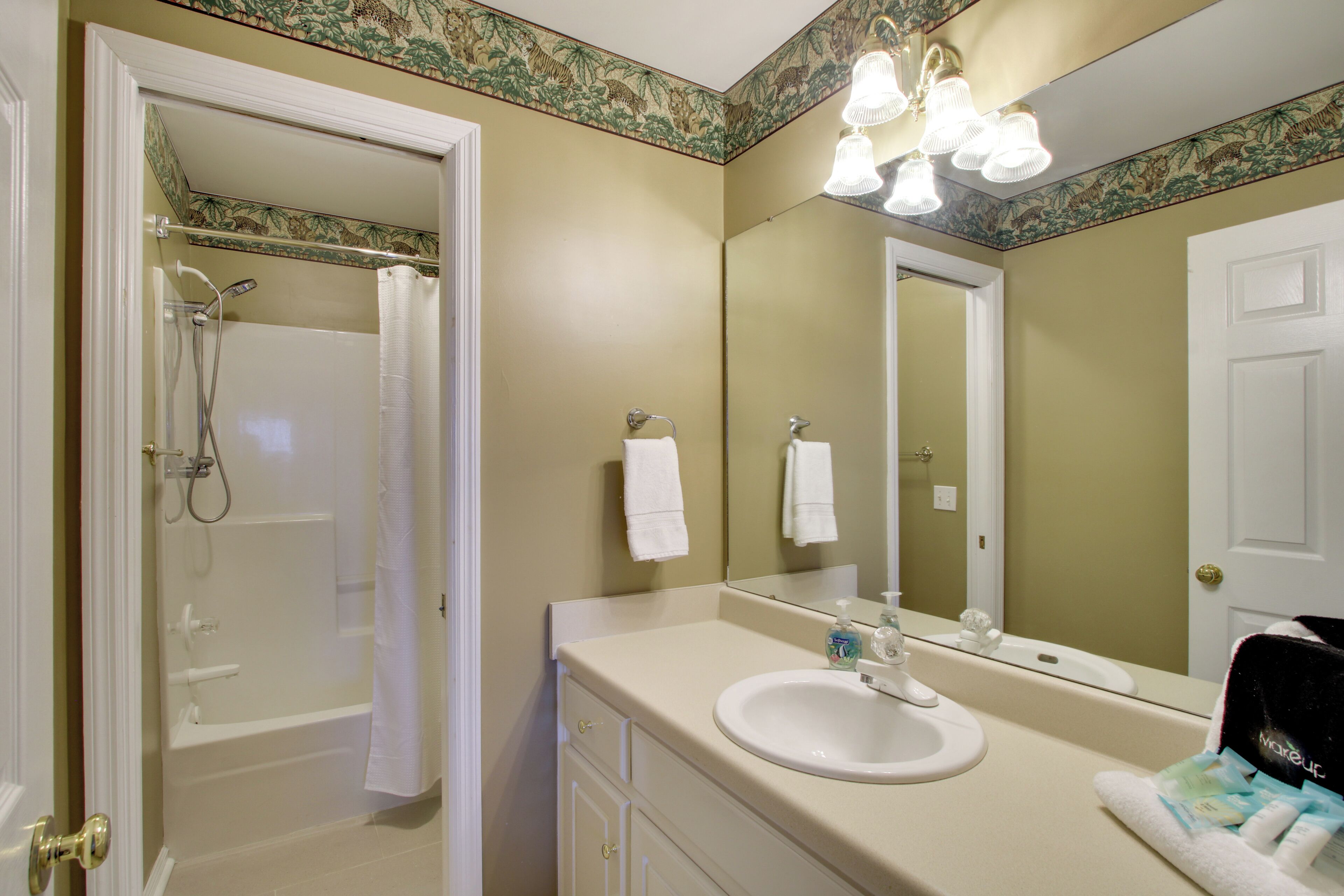 A bathroom with a bathtub, a sink, a mirror, and a shower.