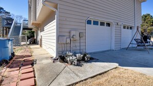 A house with a garage, a covered porch, and a brick pathway leading to the entrance.