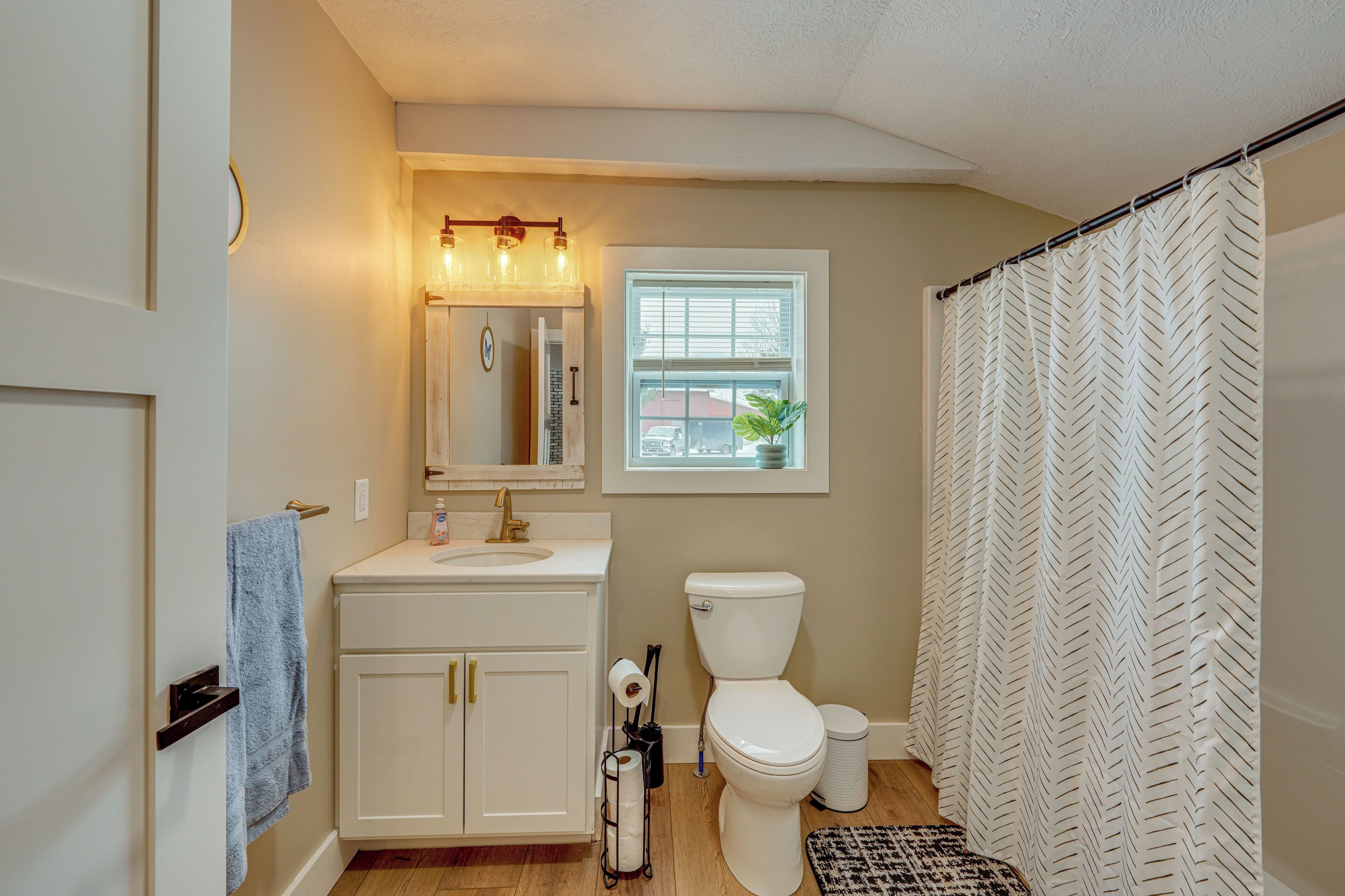 A bathroom with a white sink, toilet, and shower curtain.