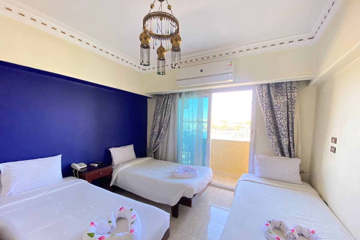 Een hotelkamer met twee bedden, een telefoon, een airconditioning en een kroonluchter.