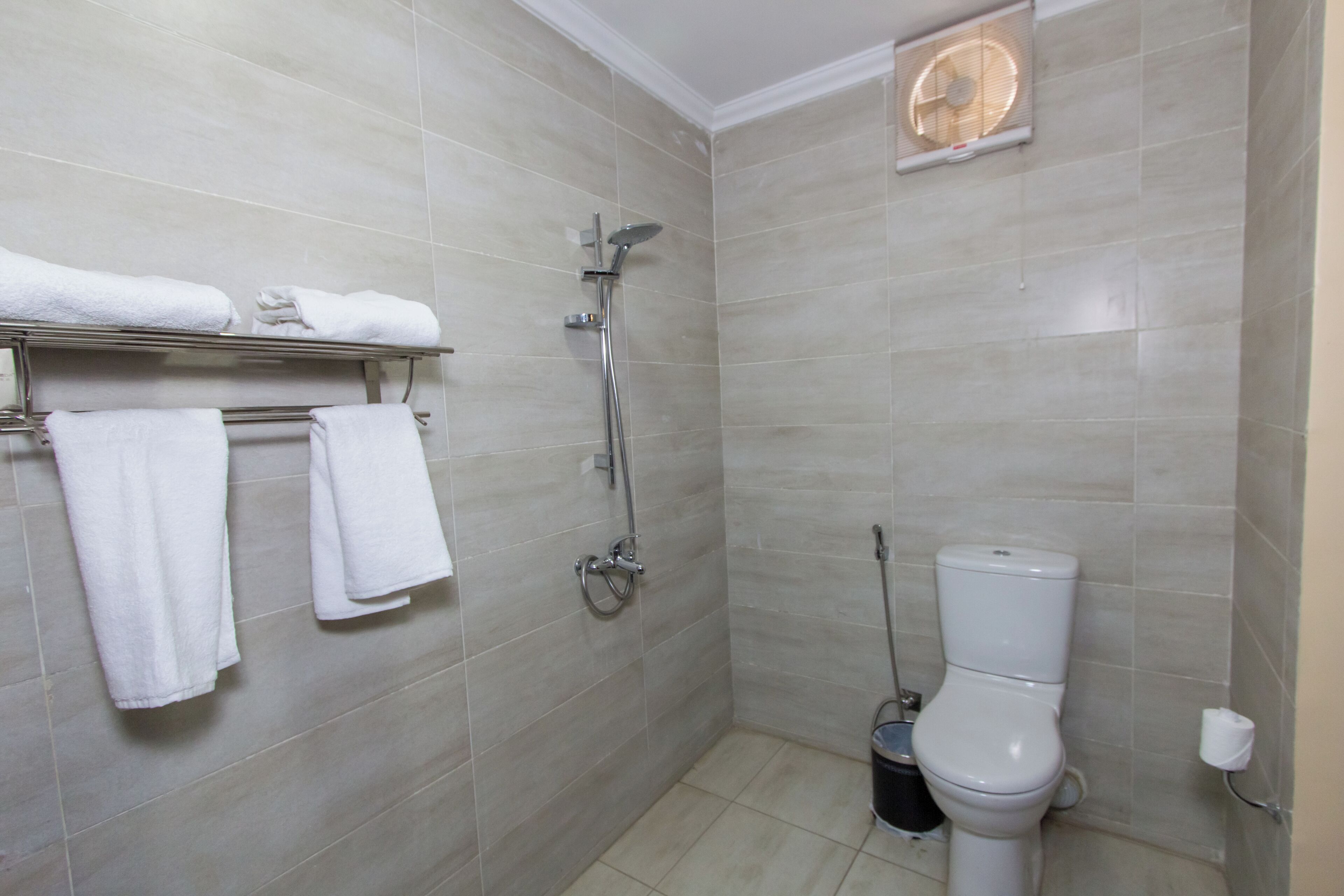 Un bagno con doccia, WC e porta asciugamani.