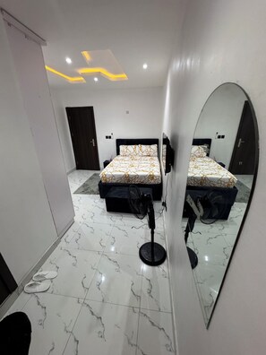 A bedroom with two beds, a large mirror, and a marble floor. - Luxury 3-Bedroom Haven in Lekki with 24/7 Power, High-Speed Wi-Fi & Private SUV (Lagos)