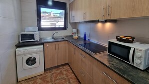 A compact kitchen with a washing machine, a microwave, and a coffee maker. - Charming house near the beach in L’Escala (L'Escala)