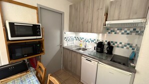 A compact kitchen with a microwave, coffee maker, and dishwasher. - Argelès-sur-Mer: Cozy 4-person apartment with terrace, near the beach (Argelès-sur-Mer)
