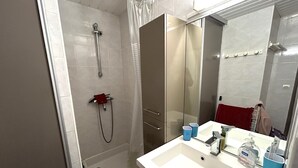A bathroom with a shower, a sink, and a mirror. - Argelès-sur-Mer: Cozy 4-person apartment with terrace, near the beach (Argelès-sur-Mer)