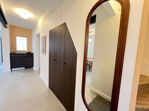 A hallway with a dark wooden door, a small window, and a desk with a chair. - Renovated House in Arcachon, Garden & AC (Arcachon)