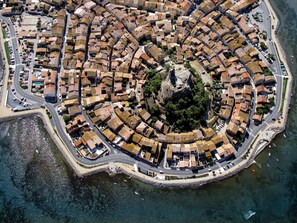 An aerial view of a coastal town with a central plaza, narrow streets, and a waterfront. - Studio for 4 with Aircon & Parking, Gruissan Port (Gruissan)