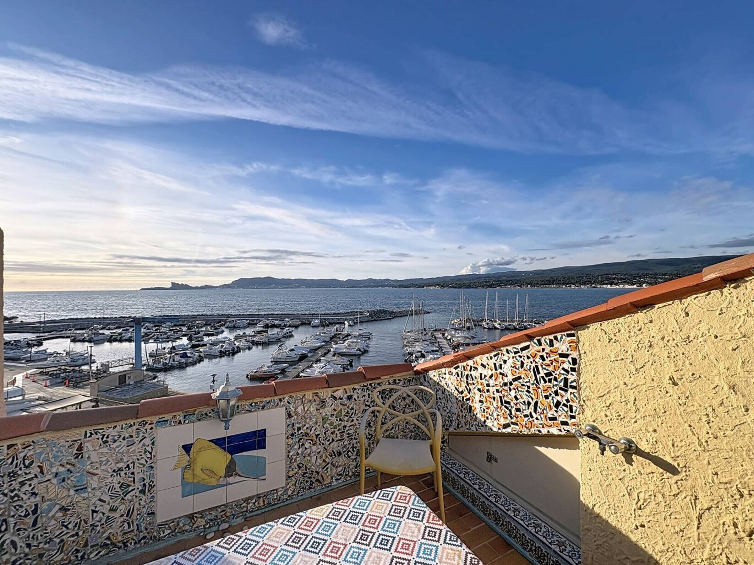 En balkon med udsigt over en havn og havet.