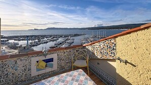 Un balcón con vista a un puerto deportivo y al mar.