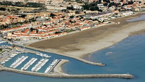 An aerial view of a coastal town with a marina, sandy beach, and residential buildings. - Apartment in Narbonne, Terrace with Sea View (Narbonne)