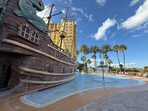 A pirate ship-themed water park with a swimming pool and palm trees. - 2bed 2bath Near Disney Piratepool Spa Balcony (Orlando)