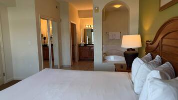 Ein Hotelzimmer mit einem großen Bett, einem Badezimmer mit einer Badewanne und einer Küchenzeile.