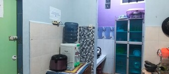 Rumah dua lantai berwarna biru cerah tampak bercahaya di malam hari