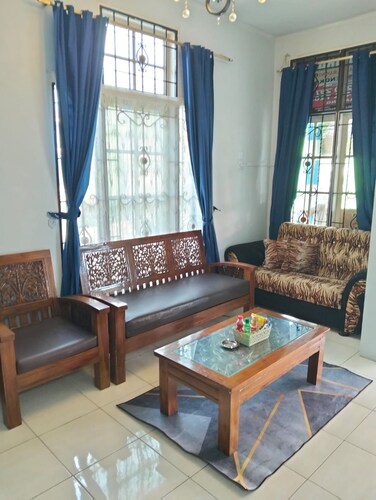 Rumah dua lantai berwarna biru cerah tampak bercahaya di malam hari