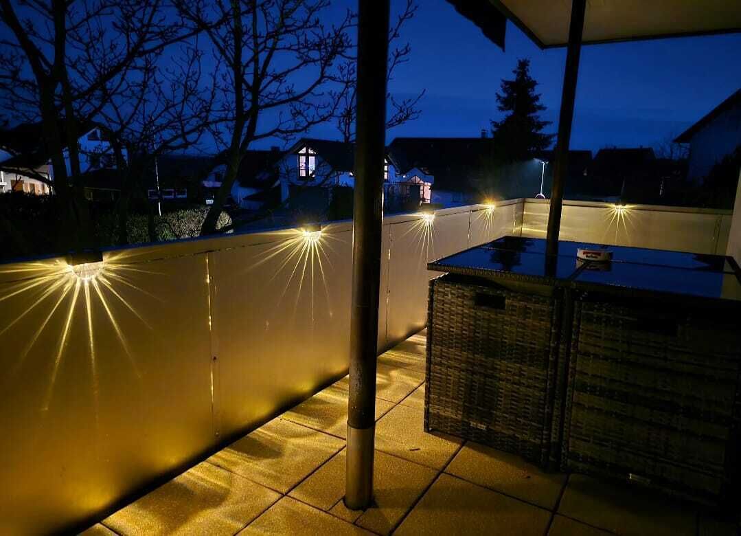 Un espace extérieur aménagé en terrasse, avec une clôture en métal, une table et un panier.