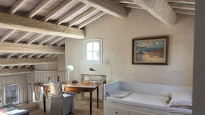A room with exposed wooden beams, a desk with a lamp, a bed, and a painting on the wall. - Luxurious Ocean View Home in South of France, Close St. Tropez (Fréjus)