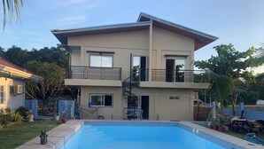 A two-story house with a swimming pool, a balcony, and a staircase leading to the upper floor. - Spacious 9-bedroom apartment in lovely Bugallon with AC (Bugallon)